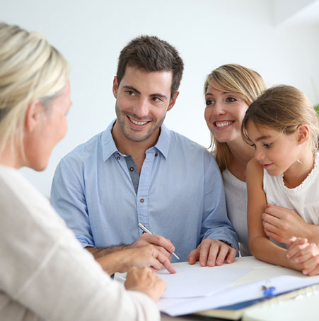 Couple en rendez-vous avec un courtier immobilier pour préparer leur futur achat immobilier