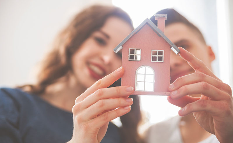 Un homme et une femme regardent une maison miniature